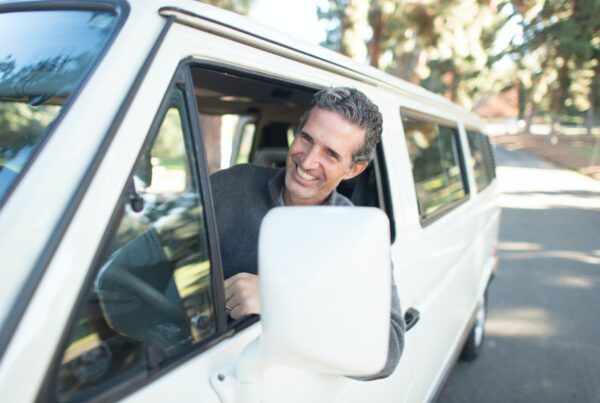 Gut gelaunter Mann fährt mit seinem Auto