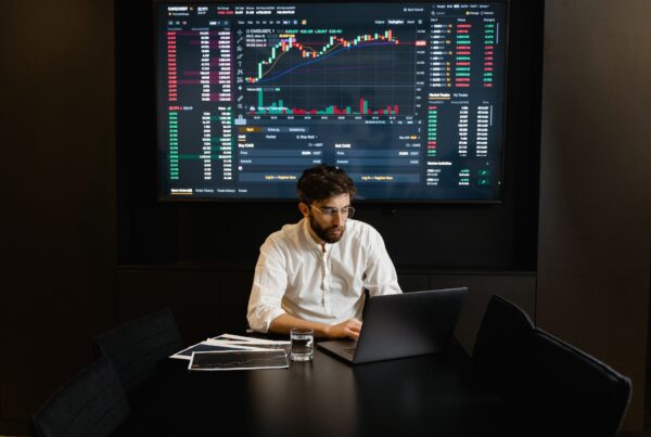 Ein junger Mann am Laptop betreibt Trading.